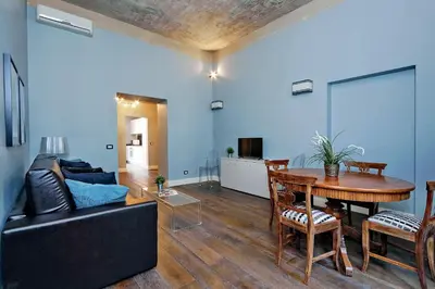 a living room with a black couch and a table at Monti Apartments - My Extra Home in Rome