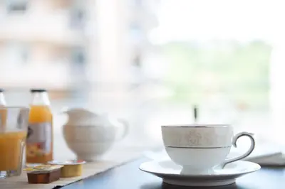 a cup and a saucer on a table with a glass at Authentic Sweet Home in Rome
