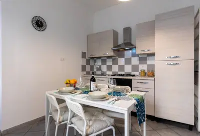 a kitchen with a white table with chairs and a counter at Trastevere 2Rooms with Balcony in Rome