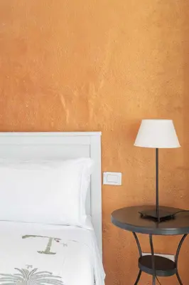 a table with a lamp next to a bed at Fontana di Trevi Modern Apartment in Rome