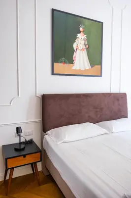 a bedroom with a bed and a painting on the wall at Stunning 1BR, 2BATH Apartment in the Heart of Rome 6C in Rome