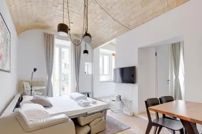 a bedroom with a bed and a dining room with a table at Charming Vatican Apartment with Balcony 6B in Rome