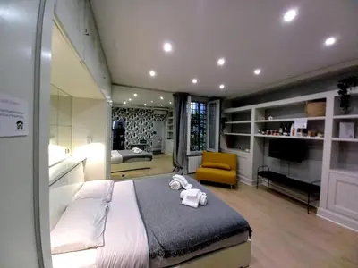a bedroom with a large bed and a yellow chair at Piazza di Spagna, ground floor, historic center in Rome
