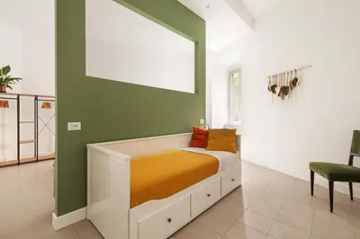 a bed in a room with a green wall at Glory House Trastevere 2 in Rome