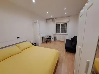 a bedroom with a yellow bed and a black chair at TowerMorange in Rome