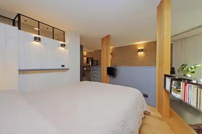 a bedroom with a white bed and a kitchen at Onofrio in Rome