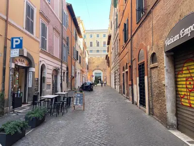 an empty street with tables and chairs in an alley at Divine Terrace Stylish Apartment St Peter Rome in Rome
