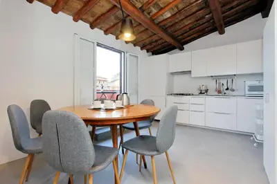 a kitchen and dining room with a wooden table and chairs at Torre Argentina in Rome