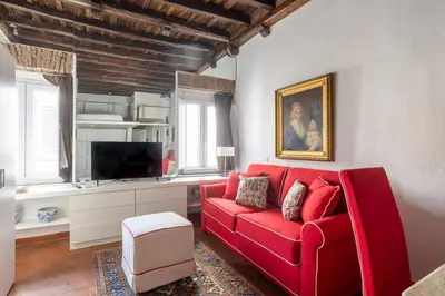 a living room with a red couch and a tv at Elegant Studio in the Center in Rome