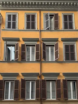a facade of a building with brown shuttered windows at Banchi Vecchi Stay Rooms in Rome