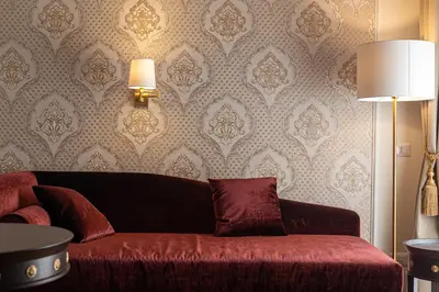 a living room with a red couch and wallpaper at L'Angolo Sereno Guesthouse Rome Termini in Rome