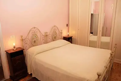 a bedroom with a white bed and a mirror at Ipanema B&B in Rome
