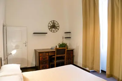 a bedroom with a desk and a clock on the wall at ColosseoHome in Rome