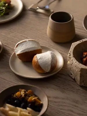 a table with plates of bread and a plate of food at Nomos Hotel in Rome