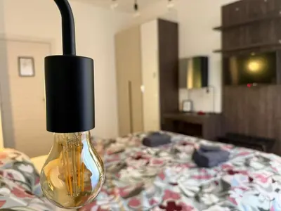 a light bulb on top of a bed at Nella House Roma in Rome