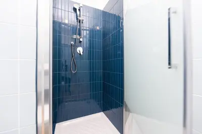 a bathroom with a shower with blue tiles at Termini Roma Imperiale in Rome