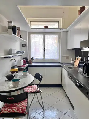 a kitchen with a table and two chairs in it at Roma San Pietro - Elegante appartamento con vista in Rome