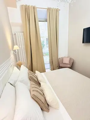 a bedroom with a white bed with pillows and a window at Seiemme Colosseo Luxury Apartment 2 in Rome