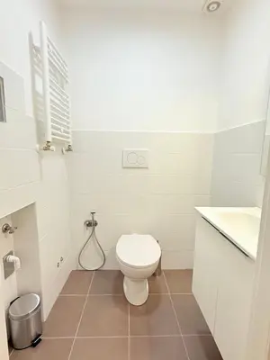 a white bathroom with a toilet and a sink at Seiemme Colosseo Luxury Apartment 2 in Rome
