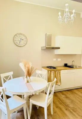 a kitchen with a table and chairs and a clock at Seiemme Colosseo Luxury Apartment 2 in Rome