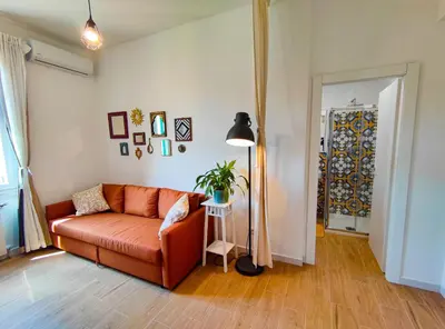 a living room with an orange couch and a lamp at Re di Room in Rome