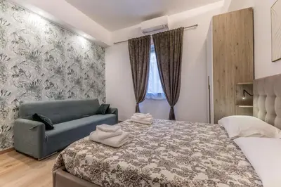a bedroom with a bed and a couch at Urbano 29 apartment in Rome