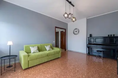 a living room with a green couch and a piano at Katia House in Rome