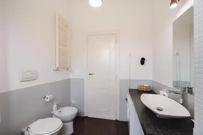 a white bathroom with a toilet and a sink at Maison 46 in Rome