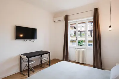 a bedroom with a bed and a desk and a window at Maison 46 in Rome