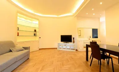 a living room with a couch and a table and a television at Scarpellini home Parioli in Rome
