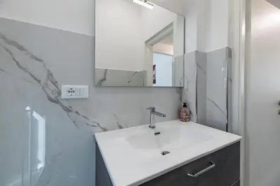 a bathroom with a white sink and a mirror at Rooma Roman Nest Garbatella - metro B line in Rome
