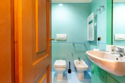 a bathroom with a toilet and a sink at The Roman Sketchpad, Few Steps from Villa Borghese in Rome