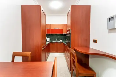 a kitchen with wooden cabinets and a wooden table at The Roman Sketchpad, Few Steps from Villa Borghese in Rome