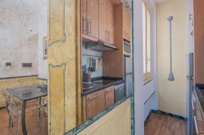a kitchen with wooden cabinets and a table in it at Roman Forum apartament in Rome