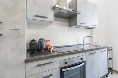 a kitchen with white cabinets and a sink at Vatican Essence in Rome