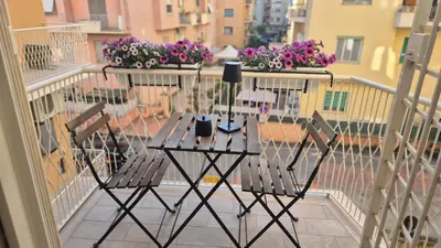 a balcony with two chairs and a table with flowers at A Casa di Nico - Metro B1 Conca d 'Oro in Rome