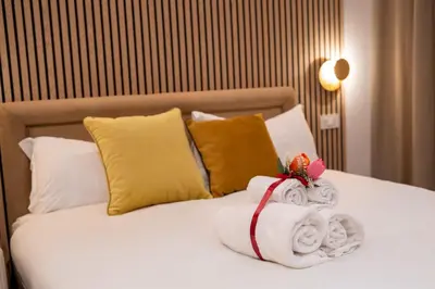 a bed with a pile of towels and pillows at Domus Augusti in Rome