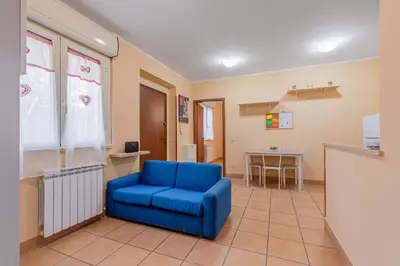a living room with a blue chair and a table at Casa Roma - La Casetta di Vale in Rome
