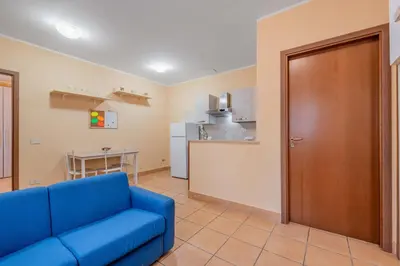 a living room with a blue couch and a kitchen at Casa Roma - La Casetta di Vale in Rome