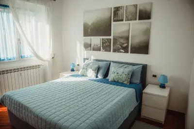 a bedroom with a bed with blue sheets and pictures on the wall at Quo Vadis APT in Rome