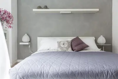 a gray bedroom with a bed with purple pillows at Santonofrio Apartments Silver e White in Rome