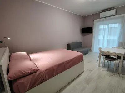 a bedroom with a pink bed and a table and chair at Sweet Home in Rome