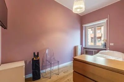 a bedroom with a bed and a desk and a window at GuestHost - Charming Apartment Metro Cipro in Rome