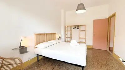 a bedroom with a white bed and a chair at Stylish Apt Balcony, AC,Aqueduct View in Rome