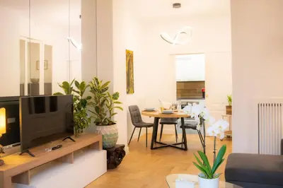 a living room with a television and a table with chairs at La Veranda dei Farnesi in Rome