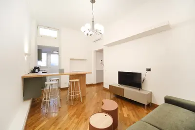 a living room with a couch and a kitchen at Dadada by BuddyRent in Rome