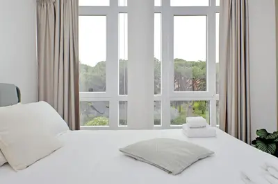 a white bed with two pillows in front of a window at Luminoso appartamento di fronte Metro Piramide in Rome