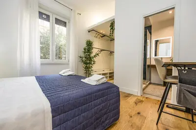 a bedroom with a blue bed and a desk at Paruta Rooms 22 in Rome