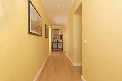 a hallway of a home with yellow walls and wooden floors at Malva Suite in Rome