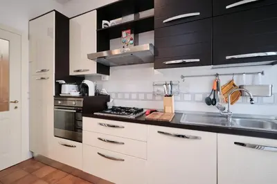 a kitchen with black and white cabinets and a sink at Residenza Lucis - Camillo Hospital - Monteverde by Hôtea in Rome